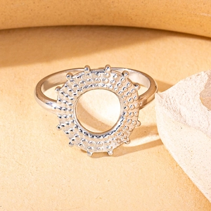 Macro detail of silver titanium steel ring featuring hollow sunburst gear texture