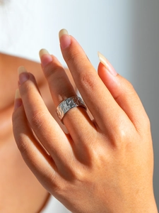Detail showing geometric diamond pattern on a minimalist silver titanium steel ring