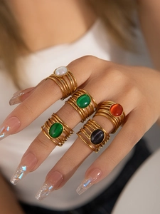 Primer plano de anillos dorados con capas y gemas ovaladas de colores estilo vintage