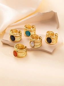 Detalle de anillos huecos de varias capas con piedras preciosas de colores y baño de oro