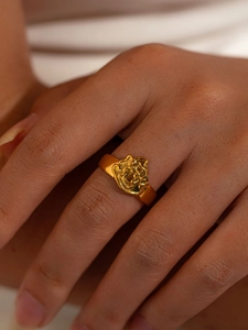Détail d'une bague en titane doré avec un motif en relief de flamme sur la main