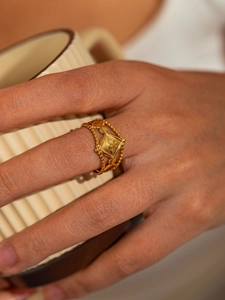 Détail d'une bague œil protecteur dorée avec anneau perlé portée au doigt