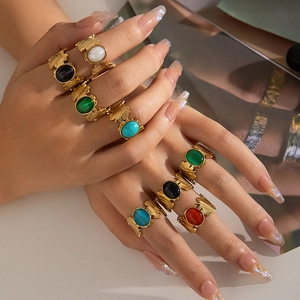 Detalle de anillos dorados vintage con gemas ovales multicolores y texturas en relieve
