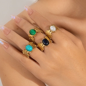 Detalle de anillos vintage dorados con piedras preciosas ovales esmeralda y turquesa