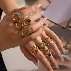 Detalle de anillos dorados con textura de lava y cuentas de piedras preciosas de colores