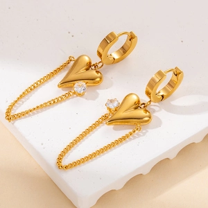 Detailed close-up of golden heart drop earrings with zircon stones and link chains
