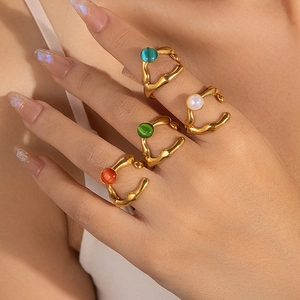 Detalle de anillos dorados ajustables con cuentas de colores en los dedos