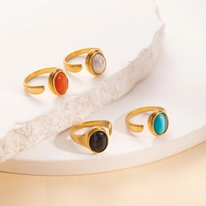 Detalle macro de anillos dorados ajustables con piedras blancas, rojas, negras y turquesas