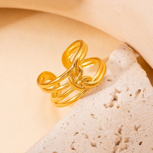 Détail macro d'une bague ajustable en acier inoxydable doré avec un design noué multicouche
