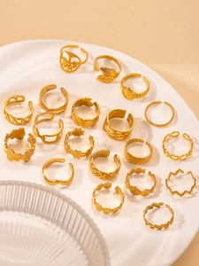Vista detallada de anillos de acero de titanio dorado con motivos de árbol de vida y hojas