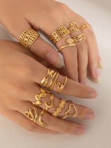 Nahaufnahme eines goldenen mehrteiligen Ring-Sets mit geometrischen Herzmustern an einer Hand