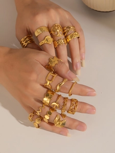 Detalle de set de anillos dorados elegantes con diseños de árboles, flores y lunas
