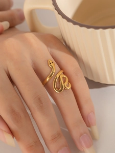 Nahaufnahme eines goldfarbenen, verstellbaren Schlangenrings am Finger im warmen Stil