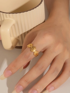 Detalle de un anillo dorado de acero de titanio con patrones de sol en relieve