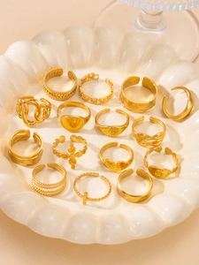 Macro view of 18K gold plated ring set featuring chain and heart patterns on white plate