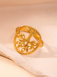 Detalle del anillo árbol de la vida dorado con textura vintage sobre fondo de piedra