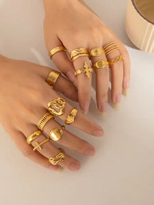 Close-up of 13-piece bohemian gold-plated ring set worn on model fingers with vintage icons