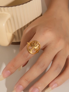 Primer plano de anillo dorado Árbol de la Vida de acero en mano con fondo de cerámica