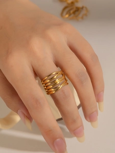 Detalle de anillo dorado de múltiples capas entrelazadas con diseño hueco y ancho