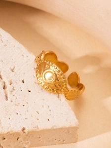 Detailed macro shot of vintage gold plated ring with wave edges and embossed round texture