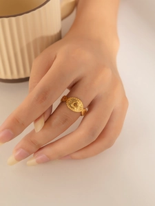 Close-up of vintage gold titanium steel ring with oval relief pattern on a model hand