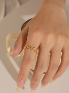 Primer plano de un anillo geométrico dorado con ondas y acabado de textura especial
