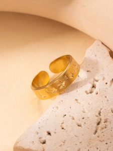 Macro detail of 18K gold-plated ring featuring embossed celestial star and moon patterns