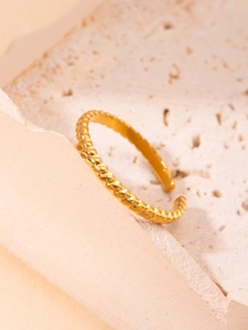 Detalle macro del anillo dorado de cuerda sobre fondo de piedra con banda ajustable