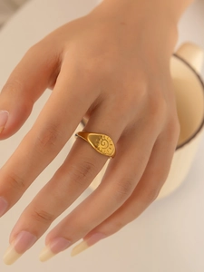 Detail of a vintage 18K gold plated signet ring with sunburst spiral design on model