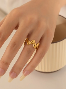 Makro-Detail des goldenen Titanstahlrings mit unregelmäßiger Kettentextur und Mattierung