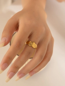 Detailed close-up of 18K gold-plated heart ring with evil eye relief on hand