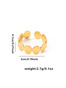 Detalle de anillo ajustable de acero de titanio dorado con dijes circulares con relieve
