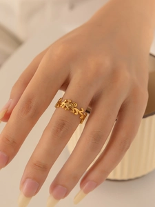 Detailansicht des goldenen, hohl geschnitzten Rings im Astdesign am Finger des Models