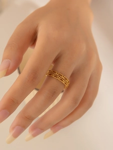 Close-up of a stacked geometric hollow gold ring on finger showing unique metalwork