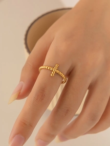 Detail showing gold beaded ring band featuring a delicate minimalist cross charm