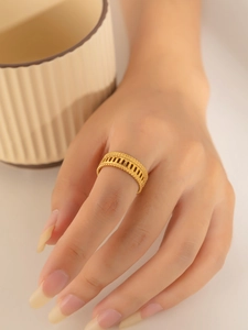 Detailed view of a wide gold titanium ring featuring hollow rectangles and beaded edges