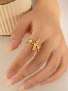 Detail shot of a minimalist gold-plated titanium steel ring with unique cross disc design