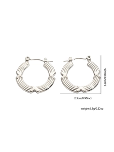 Macro shot of silver titanium steel earrings with triple vertical grooves and X patterns