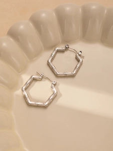 Close-up of silver hexagonal earrings featuring a unique bamboo-textured finish