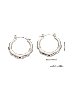 Macro shot showing dimensions and weight of silver textured geometric hoop earrings
