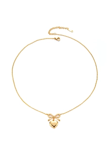 Detailed view of golden bow and heart pendant necklace with refined lobster clasp
