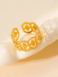 Detail view of gold titanium steel open ring with hollowed floral carvings