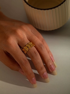 Detailed view of a gold titanium steel ring featuring an olive leaf design on hand