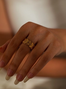 Detailed view of gold titanium steel ring featuring a continuous laurel leaf design