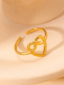 Detailed close-up of a gold titanium ring featuring a hollow heart and infinity symbol design