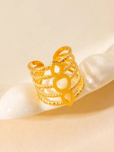 Macro shot of gold-plated multi-layer open ring featuring twisted rope textures and geometric cutouts