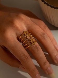 Macro shot of gold layered rope texture ring with oval cutouts on finger