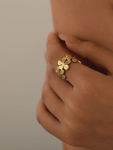 Close-up of gold hollow ring featuring floral patterns and radial texture details
