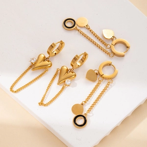 Macro view of gold stainless steel heart pendant and enamel hoop earring set details