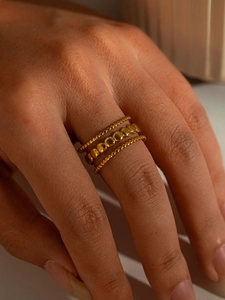 Close-up of triple-layered golden beaded titanium steel ring showing polished details
